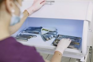 healthcare professional organizing sterilized medical instruments in a storage unit