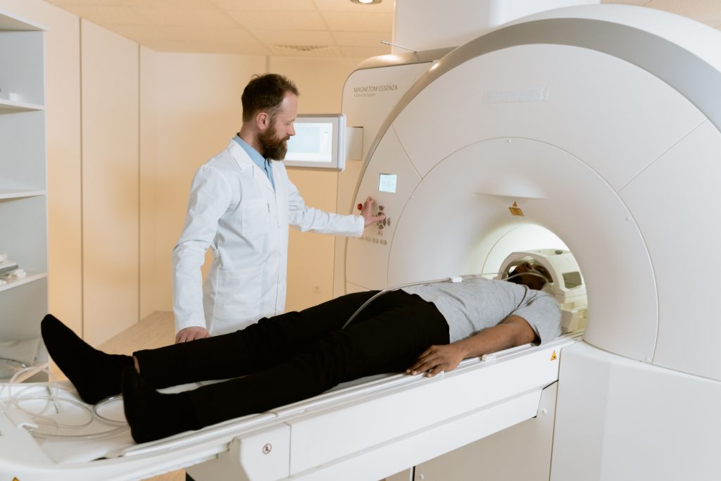 Biomedical service engineer performing diagnostic checks and preventive maintenance on a CT scanner gantry.
