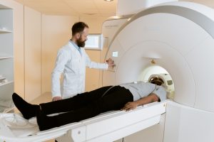 Biomedical service engineer performing diagnostic checks and preventive maintenance on a CT scanner gantry.